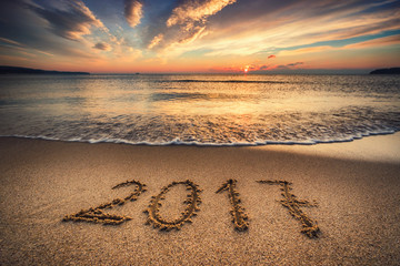Happy New Year 2017 concept on the sea beach at sunrise