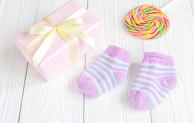 baby socks and gift box on wooden background
