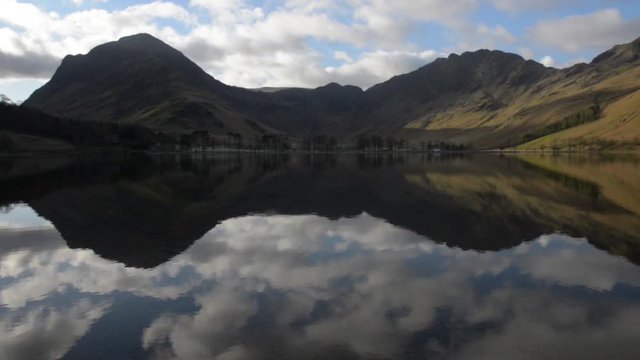 Reflections of Cumbrian mountain on lake Buttermere in English lake district.