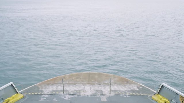 Looking down on the bow (front) of a vehicle transportation ferry as it moves across the sea