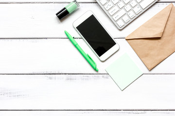 female wooden desktop with smartphone, paper envelopes top view
