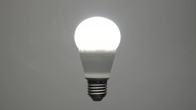 Energy saving led bulb turning on from darkness