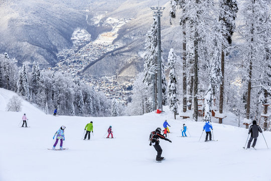 Skiers and snowboarders riding on a ski slope in Krasnaya Polyana Sochi all season resort