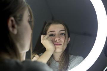 Portrait of teenage looking in a mirror - 127760500