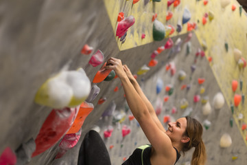 Fototapeta na wymiar sporty woman in boulder climbing hall