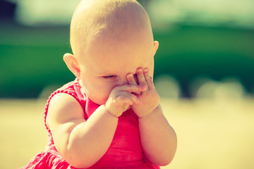 Little baby hiding face in hands