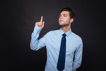 Concentrated businessmna standing isolated on black background