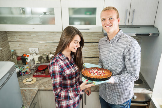 Portrait of a young couple preparing food in the kitchen.