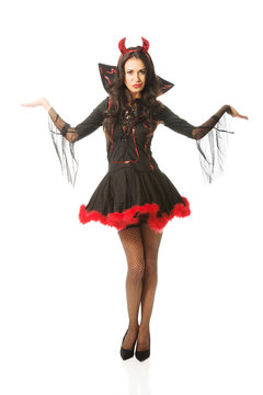 Full length woman standing with open gesture wearing devil clothes