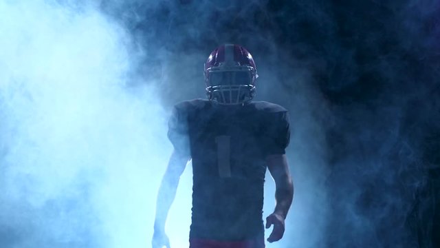 Football go out is in our protective gear in the smoke. Slow motion