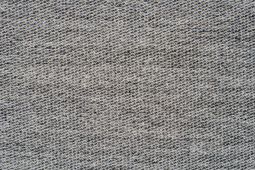 Heather grey knitted fabric made of synthetic yarn. Textured background.