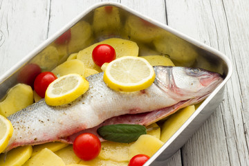 Fish with lemon potatoes and tomatoes ready for the oven