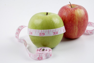 apple and measuring tape on white. Healthy concept
