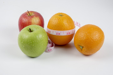apple ,orange and measuring tape on white. Lifestyle concept