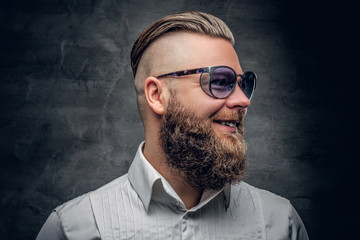 A bearded man in purple sunglasses isolated on grey vignette bac