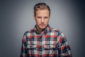 A man dressed in a red plaid shirt isolated on grey vignette bac