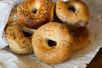 Variety of Authentic New York style bagels with seeds in a paper bag