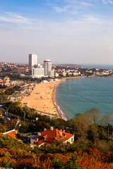 View of bathing beach N1 from the hill of Xiao Yu Shan Park in autumn, when the hill is covered in red leaves. Qingdao, Shandong province, China