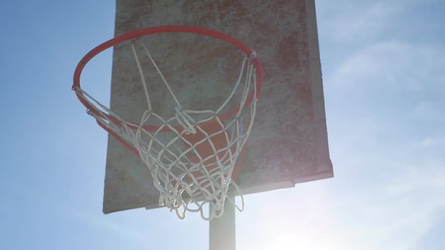 old basketball hoop against a blue sport street