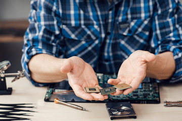 Computer microchips in male hands, close-up. Computer repair shop, electronic engineer workplace...