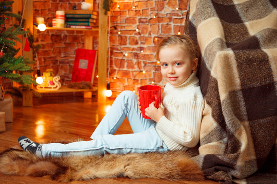 Picture of a girl hand holding a red coffee mug.  Merry Christmas