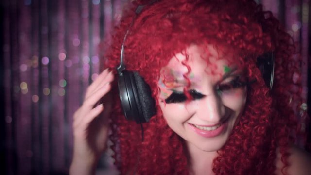 4k Disco Redhead Sexy Woman Listens to Music with Headphones and Smiling