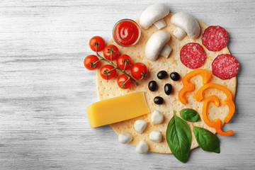 Fototapeta na wymiar Raw pizza ingredients on wooden background, top view