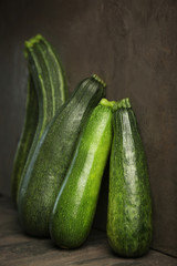Fresh zucchini on gray concrete wall background