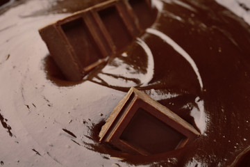 Delicious melted chocolate with pieces, closeup