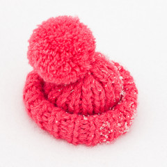Вязаная красная шапка на снегу