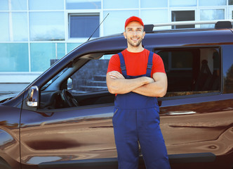 Delivery man standing beside car