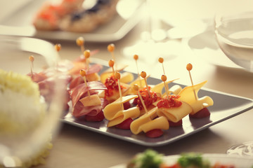 Tray with tasty canapes on wooden table, close up view