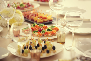 Plate with tasty tartlets on table served for holiday buffet, close up view