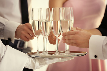 Waiter serving champagne during  buffet catering party, close up view