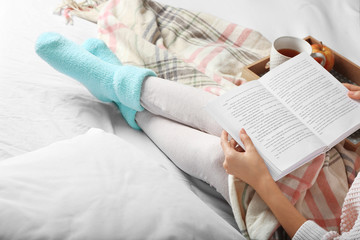 Fototapeta premium Girl with food reading book on bed