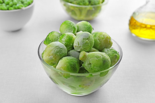 Frozen brussels sprout in bowl on light background