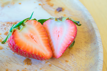 Fresh strawberry on the wooden plate with ice cream.