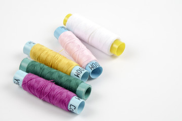 Sewing colored threads isolated on white background