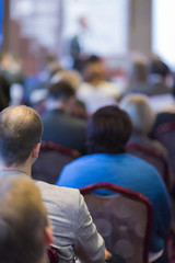 Group of People Attending Conference and Listening to the Host Standing In Front of Big Screen