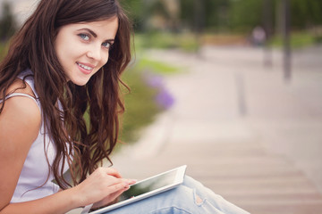 Modern girl student holding an electronic tablet