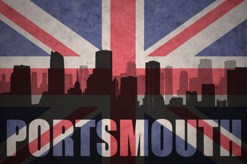abstract silhouette of the city with text Portsmouth at the vintage british flag