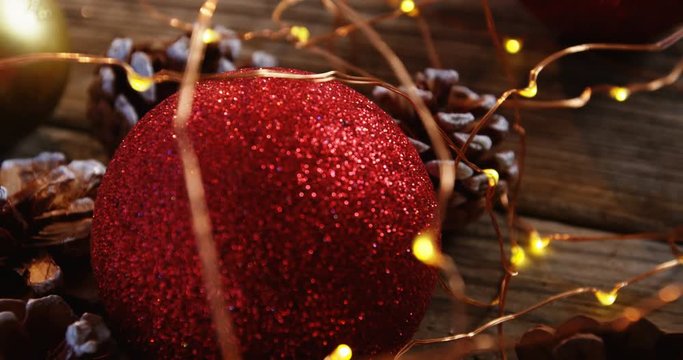 Christmas bauble and pine cone arranged with christmas lights
