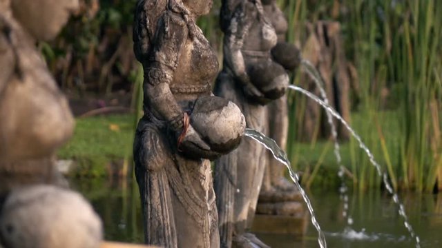 View of fountain with ancient, Hindu sculpture in garden, super slow motion 240fps
