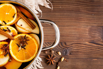 preparation of mulled wine in pot wooden background top view