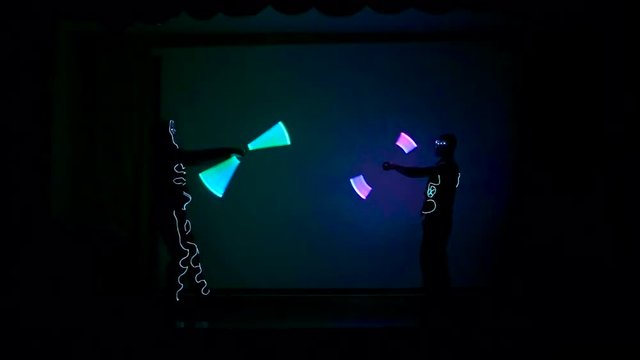 Men twist fiery circles on a LED show.