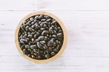 Black beans in a bowl on wooden table