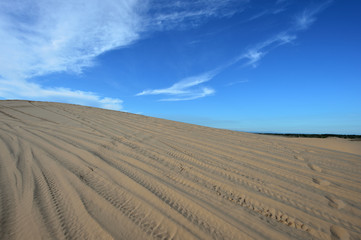 Blue cloudy sky over sand dunes in the evening