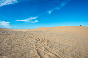 Blue cloudy sky over sand dunes in the evening