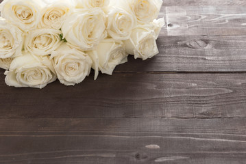 White roses flower are on the wooden background