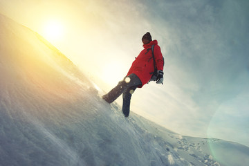 Woman traveler in a bright jacket walking on snow drifts. Lens flare effect